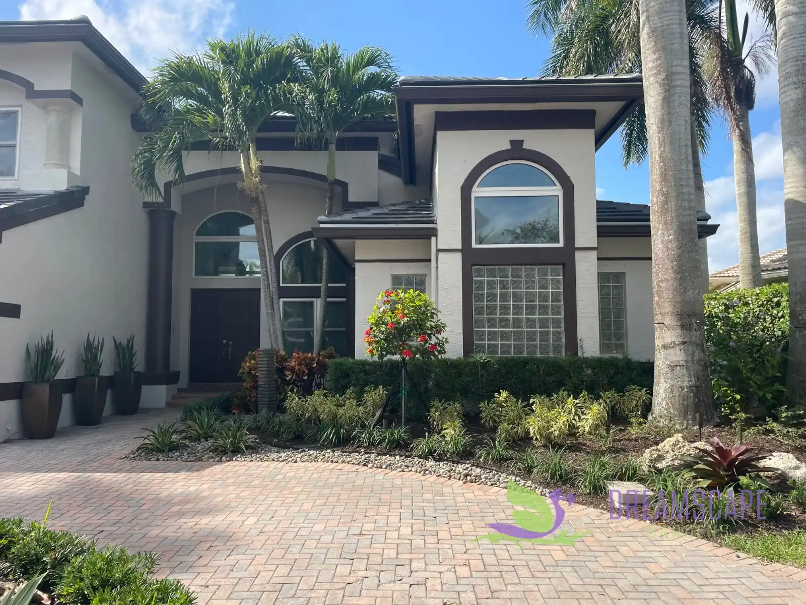 Front entrance in Saturnia, West Boca Raton: royal palms, colorful shrubs, a basalt fountain and glazed ceramic pots