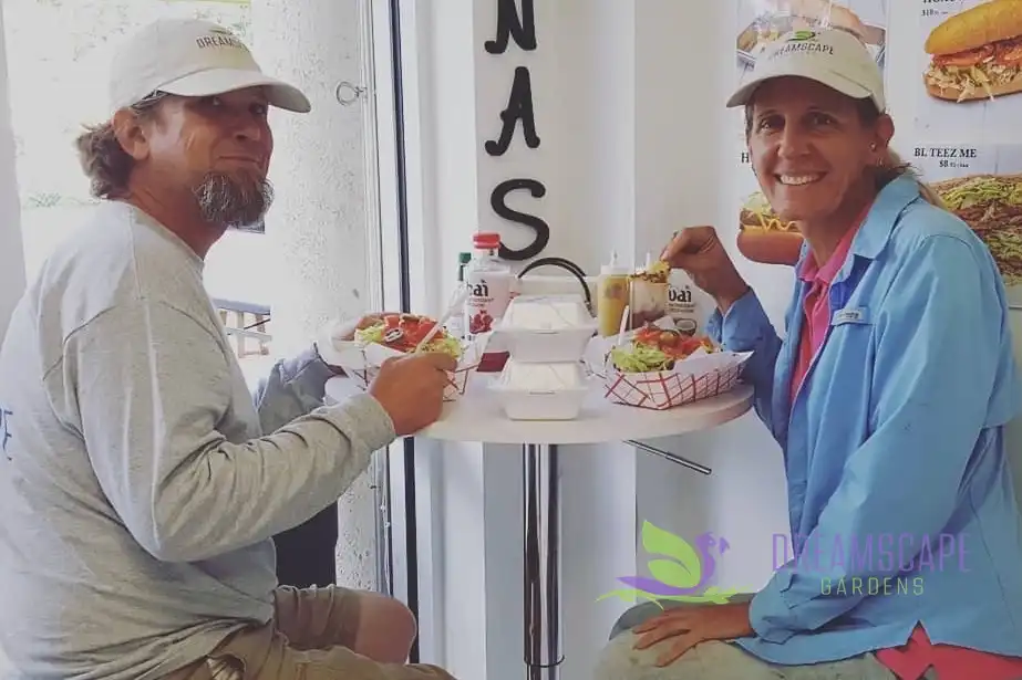 Jennifer Mennuti and Travis Maple, both wearing Dreamscape Gardens caps